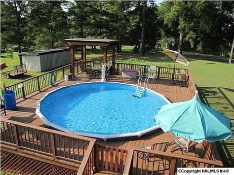 Here we see another deck all the way around a round above-ground pool. This deck is an amazing gathering spot for family pool times. Wood Pool Deck, Ideas De Piscina, Round Above Ground Pool, Above Ground Pool Deck, Pool Deck Plans, Best Above Ground Pool, Swimming Pool Decks, Round Pool, Above Ground Pool Landscaping