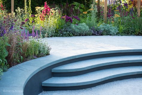 Curved limestone steps wrap around a relaxed seating area to form a bench backed by a border full of colourful planting Curved Steps, Limestone Steps, Hampton Court Gardens, Tom Simpson, Timber Posts, Exterior Stairs, Concrete Steps, Garden Designer, Bold Color Palette