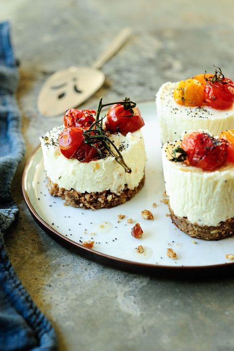 Creamy cheesecakes with goat cheese on a crispy crackers crust, served with roasted cherry tomatoes and poppy seeds. The crust is slightly sweetened with Savory Cheesecake, Roasted Cherry, Roasted Cherry Tomatoes, Mini Cheesecakes, Snacks Für Party, Poppy Seeds, Roasted Tomatoes, Goat Cheese, Finger Food