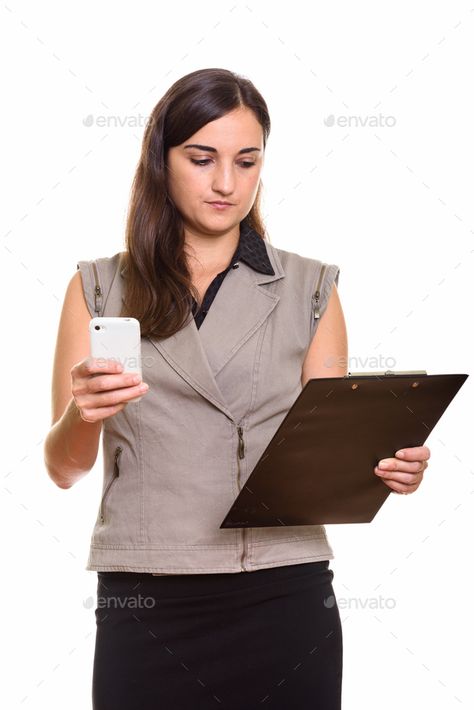 Portrait of young beautiful businesswoman using phone while holding clipboard by amazingmikael. Studio shot of young beautiful businesswoman isolated against white background #Sponsored #businesswoman, #phone, #holding, #Portrait Holding Phone Reference, Phone Reference, Holding Clipboard, Holding Phone, Using Phone, Poses Reference, Human Poses Reference, Human Poses, Studio Shoot