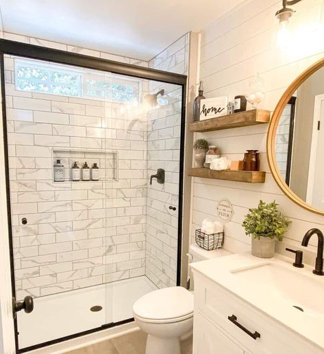 A clear glass panel door exposes the bright white modern wall tiles within this small bathroom shower. The rectangular subway style of the marble tiling gives it a unique flare and a modern finish that goes well with the black fixtures, gold framed mirror, and white shiplap walls...   Image: doodledream.life White Shiplap Walls, Modern Wall Tiles, Small Farmhouse Bathroom, Beautiful Small Bathrooms, Walk In Shower Ideas, Black Painted Walls, Black Fixtures, Small Bathroom With Shower, Subway Style