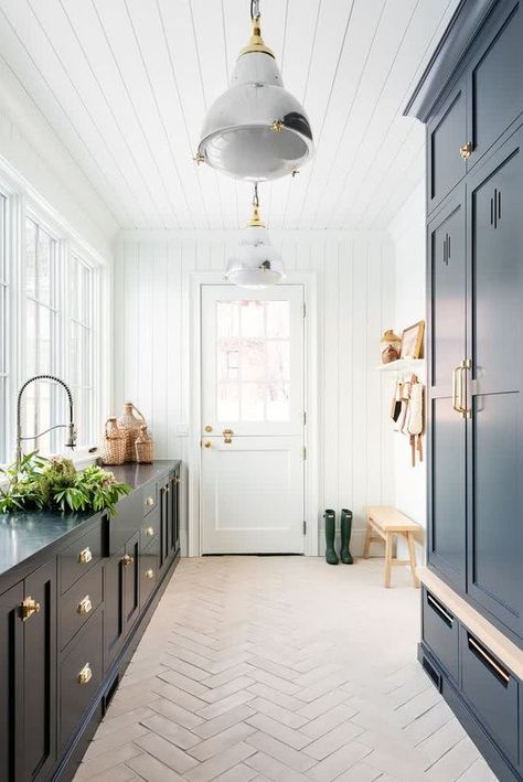 Picture of a stylish farmhouse mudroom with navy cabinetry and a herringbone tile floor, a bench and some baskets Laundry Herringbone Floor, Large Herringbone Tile Floor, Herringbone Floor Kitchen, Balcony Trellis, Herringbone Tile Floor, Stylish Farmhouse, Balcony Herb Gardens, Colorful Outdoor Furniture, Irish Kitchen