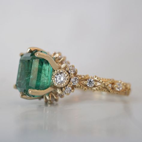 Bring elegance and sophistication to your jewelry collection with this one of a kind Emerald Knightsbridge Diamond Ring. Handcrafted in your choice of 14K and 18K Gold, this regal piece features a stunning natural emerald centerpiece surrounded by dazzling diamonds. As impressive as it is dreamy, this ring is sure to become a treasured family heirloom. Only one available. 14K or 18K solid gold Natural asscher cut emerald. 4.44 carat weight. Comes with a certificate. Natural round white diamonds. Royal Rings Aesthetic, Emerald Wedding Ring Vintage, Emerald Engagement Ring Unique, Gold Emerald Engagement Ring, Vintage Emerald Ring, Diamond And Emerald Ring, Gold Emerald Ring, Emerald Ring Vintage, Fall Rings