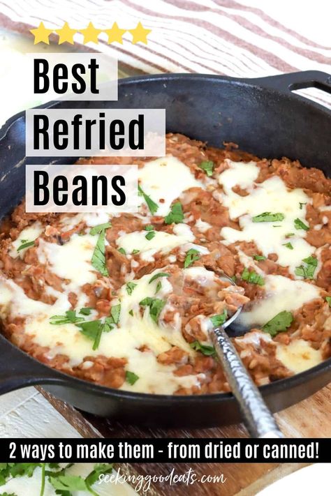 A cast iron skillet of refried beans with cheese and cilantro How To Cook Refried Beans From A Can, Refried Bean Side Dish, The Best Refried Beans, Refried Beans With Cheese, Doctored Refried Beans, Refried Beans Tostadas, Mexican Burritos Authentic, Seasoned Refried Beans, Restaurant Refried Beans From A Can