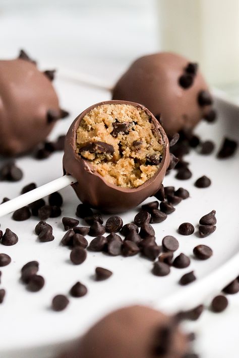 close up view of easy cookie dough cake pops with mini chocolate chips scattered Cookie Dough Cake Pops Recipe, Chocolate Chip Cake Pops Recipe, Baileys Cake Pops, How To Make Cake Balls, Cookies And Cream Cake Pops, Cake Pop Easy, Peppermint Brownie Cake Pops, Cake Dipped In Chocolate, Starbucks Cookie