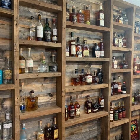 Home bar with bourbon display shelves using reclaimed barn wood Small Bar Display, Shelving For Liquor Bottles, Floating Shelves For Liquor Bottles, Bourbon Bottle Display Ideas, Liquor Bottle Shelf Display Diy, Small Rustic Bar Ideas, Wall Bar Shelves, Drinks Display Ideas, Basement Bar Liquor Display