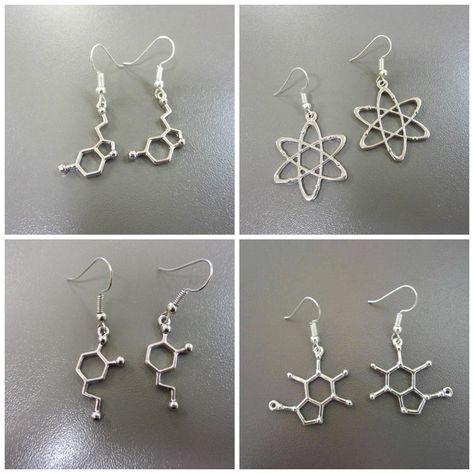 Grab this collection of four pairs of science themed earrings!  (Also available separately) One pair of serotonin molecule charm earrings, one pair of caffeine molecule earrings, one pair of dopamine earrings, and one pair of carbon atom earrings. These molecular and atomic earrings are made from silver coloured metal, and hang from plated ear wires. Quite large sized charms; from 4cm to 5cm long Chemistry Earrings, Atom Earrings, Science Earrings, Serotonin Molecule, Caffeine Molecule, Science Jewelry, Funky Earrings, Funky Jewelry, Themed Jewelry