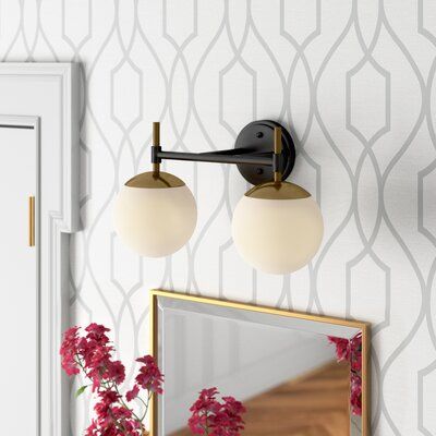 This 2-light vanity light pairs modern and glam elements together, making it perfect for updating the aesthetic of your powder room in your main room or guest room. It's crafted from metal, and it features a round backplate, angular arms, and a slender horizontal rod in a solid finish for a minimalist feel. A pair of glass globe shades round out this design with a sleek touch, diffusing light from compatible 60W medium-base bulbs (not included) up or down thanks to its reversible mounting design Black Vanity Light, Wall Mount Faucet Bathroom, Bathroom Vanity Light, Double Bathroom Vanity, Led Vanity, Bathroom Light Fixtures, Globe Lights, Bathroom Vanity Lighting, Diffused Light