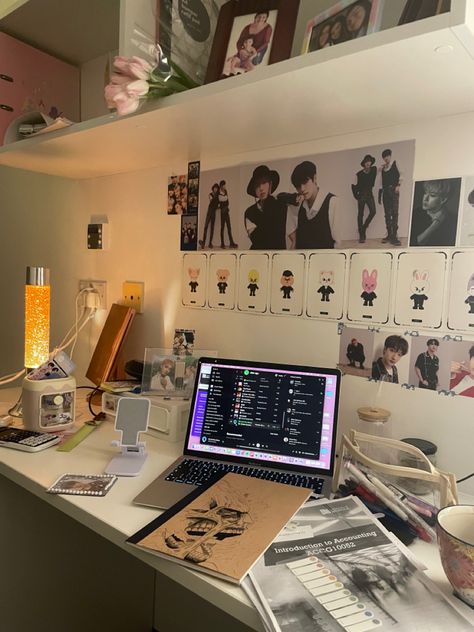 There is a macbook on the table with a stack of accounting notes and a notebook with a colossal titan from attack on titan next to it. There is a lava lamp on the side and the wall is decorated with stray kids posters and pictures Kpop Themed Room Aesthetic, Skz Bedroom Aesthetic, Aesthic Room Decor Idea, Skz Bedroom Ideas, Daizchoii Room, Kpop Aesthetic Room Ideas Skz, Kpop Room Inspo Skz, Stay Room Decor Skz, Stray Kids Bedroom