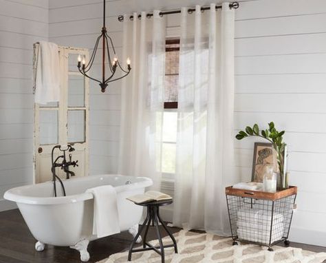 Vintage chandelier hanging over a clawfoot bathtub. Chandelier Over Claw Foot Tub, Chandelier Above Bathtub Soaking Tubs, Chandeliers Above Bathtubs, Chandelier Over Clawfoot Tub, Chandeliers Over Bathtubs, Chandelier Over Bathtub Farmhouse, Bathroom Chandelier Over Tub Farmhouse, Over The Bathtub Lighting, Bathtub Lighting Fixture