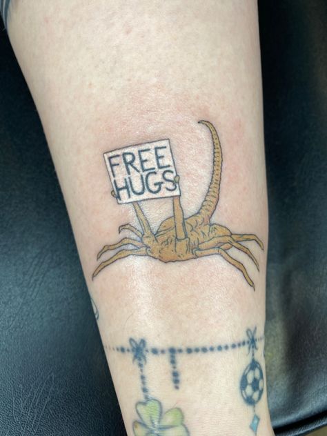 Facehugger tattoo from the movie, “Aliens” . Holding up a sign that says,”free hugs”. Avp Tattoo, Face Hugger Tattoo, Alien Face Hugger Tattoo, Alien Movie Tattoo, Alien The Movie Tattoo, Facehugger Tattoo, Alien Tattoos, Aliens Tattoo, Xenomorph Tattoo Ideas