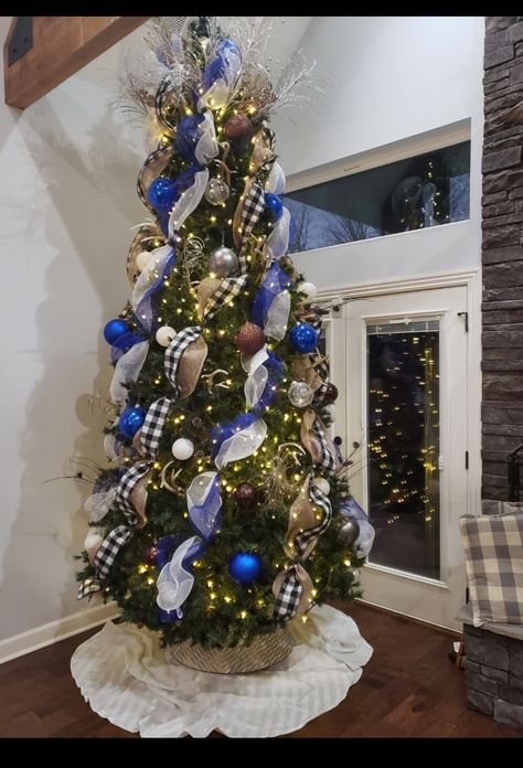 Our 12 ft Christmas Tree with blue and white mesh, buffalo plaid wide ribbon and burlap in wide also. Love how this turned out. #ChristmasTree #Christmas #ChristmasDecor #HolidayDecorations #DecoratingWithMesh Blue Buffalo Plaid Christmas Tree, Blue And Silver Christmas Tree Ideas, 12 Ft Christmas Tree, Blue Christmas Tree Decorations, Navy Christmas, Buffalo Plaid Christmas Tree, Tree Themes, Blue Christmas Tree, Silver Christmas Tree