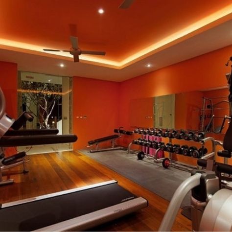 If your home gym feels a bit more like a hole than a home, give these easy tricks a try to up the morale while you're on the treadmill. Orange Gym, Gym Lighting, Mini Gym, Basement Gym, Exercise Room, Home Gym Decor, Home Gym Design, Gym Room, Orange Walls