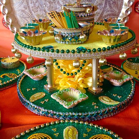 A double tiered Mehndi plate in traditional colours, an oil and Mehndi pot has been added for that extra wow factor.  See my Facebook page www.facebook.com/mehnditraysforfun for more inspirational ideas. Mehndi Taals Ideas, Mehendi Thali Decor Ideas, Mehndi Thali Decoration Ideas, Mehndi Thaal Ideas Trays, Haldi Mehndi Plate Decoration, Mehndi Plate, Mehndi Thali Decoration Ideas Pakistani, Mehndi Decor Plates, Thali Decoration Ideas