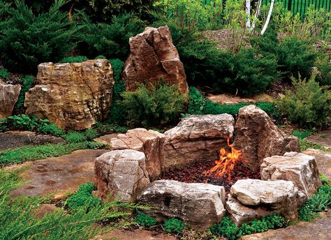 perhaps a little too rustic, but i like the natural look of the fire pit with soft plants surround it Fire Pit Surround, Boulder Fire Pit, Outdoor Fire Pit Ideas, Natural Fire Pit, Rustic Outdoor Fireplaces, Backyard Bbq Pit, Outdoor Fire Pit Area, Outside Fire Pits, Fire Pit Swings