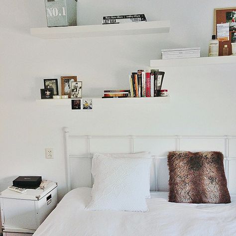 White shelving practically disappears against matching white walls, leaving the illusion of floating books and art. Shelves Above Bed, White Shelving, Shelves Tv, Shelf Above Bed, Floating Shelves Bedroom, Shelf Decor Bedroom, Decor Above Bed, White Floating Shelves, Ideas For Decorating