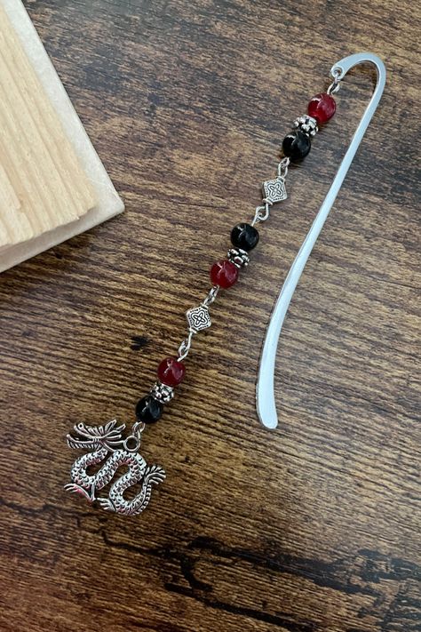 Save your page with this beautiful, unique bookmark created by hand using red and black beads with a serpentine dragon charm. The silver hook bookmark measures 3.5 in. Wire Wrapped Bookmark, Beadable Bookmark, Bookmark Charms, Jewelry Bookmarks, Bookmark Ideas, Garden Totems, Beads Craft, Beaded Bookmarks, Unique Bookmark