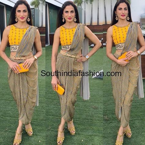 Shilpa Reddy attended an event recently wearing a printed dhoti saree paired with yellow crop top. She accessorized her outfit with matching yellow box clutch, nude belt, tan heels and statement gold earrings. Bright lips and straight hair rounded out her look! jewellery with dhoti sarrees, mrs india telangana Dhoti Pattern Dress, Dhoti Pattern, Shilpa Reddy, Dhoti Saree, Saree Wearing Styles, Saree Wearing, Saree Draping Styles, Sari Design, Saree Blouse Designs Latest