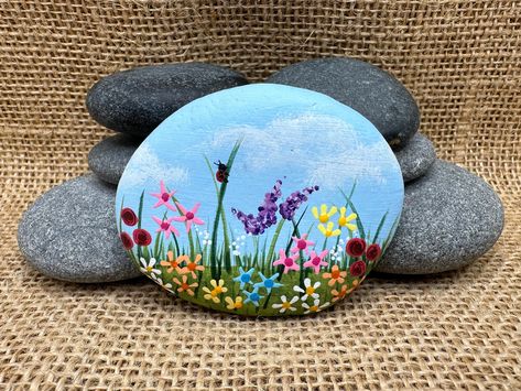 "🖐️ Hand Painted 📦 FREE Shipping From California 📐 Approximate Size: 2 1/2\" x 2\" This hand-painted rock of a lively field of colorful flowers, accentuated by the whimsical presence of a ladybug, makes this piece a delightful addition to any space. The intricate details and vibrant hues bring a touch of nature indoors, creating a unique and enchanting focal point. Perfect for gifting or enhancing your surroundings with the beauty of blooming flora and a touch of whimsy. The back of the rock A Ladybug, Flowers Painted, Colorful Bags, Rock Painting Designs, Rock Painting Art, Hand Painted Rocks, Rock Crafts, Painted Rock, Pebble Art