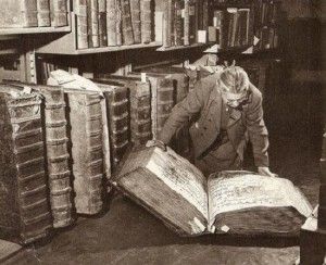 Those are late-medieval choir books. Before paper replaced vellum, book production was hideously expensive. Making a copy of the music was a multi-year undertaking involving several skilled professionals (tanners, binders, icopyists, etc). The preferred solution was to have one massive book per cathedral that everyone read simultaneously. That one book needed to be huge so that the singers in the back row of the choir could also see the notes. Giant Library, Stacks Of Books, Man Reading, Prague Castle, Isaac Asimov, Medieval Manuscript, Nikola Tesla, Reading A Book, E Card