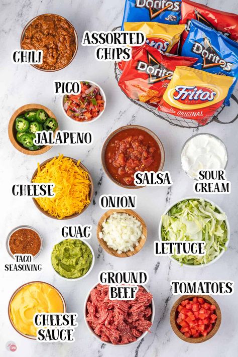 These walking tacos are the perfect way to feed a crowd. Inexpensive, easy to make, and everyone loves them! Grab your favorite chips and keep all your toppings in a crockpot while everyone eats. Perfect for tailgating and camping! #superbowl #tailgating #biggame #gameday #foracrowd #recipe Walking Tacos For Graduation Party, Walking Tacos Bar Wedding, Taco Bar Easy, Easy Walking Tacos, Walking Tacos For A Crowd Parties Food, Camping Taco Bar, Healthy Taco Night, Walking Tacos Party Ideas, Walking Taco Board Ideas