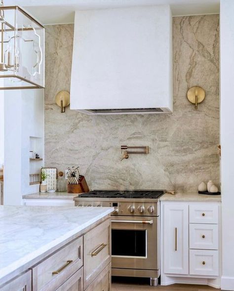 Designer Appliances on Instagram: "May the approaching new year be as clean *and* bright as this stunning kitchen! 🤍 The quartz (Taj Mahal) backsplash adds a touch of glamour and elegance, while the brass hardware gives the space a sophisticated and upscale feel. And to top it all off, a @cafeappliances range completes the look with its high-end, professional-grade features. The overall effect is a kitchen that is both comfortable and chic, making it the perfect place to cook and entertain. 🙌 Range Hood With Sconces Kitchen, Kitchen Sconces Range, Taj Mahal Quartzite Backsplash, Taj Mahal Quartz, Stucco Vent Hood, Taj Mahal Backsplash, Quartz Kitchen Backsplash, Taj Mahal Kitchen, Quartz Backsplash Kitchen