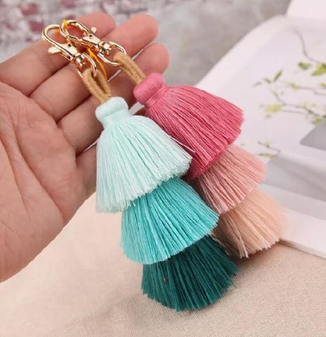 Fringe: Keychains are decorated with soft fringes, usually made from wool, fabric, or rope. These fringes create a moving effect and add charm to the accessory. Pom Pom: Colorful pom poms are attached to the keychain. Pom poms are usually made from wool or fabric, giving a cute and fun feel. The colors of pom poms can be varied, from soft pastel tones to bright colors, helping to create a striking highlight. Key Chain Material: The keychain is usually made from sturdy metal, which can be silver, Tassel Bag Charm, Tassel Keyring, Boho Handbags, Tassel Keychain, Chain Fashion, Tassel Bag, Colorful Boho, Accessories Bracelets, Key Holder