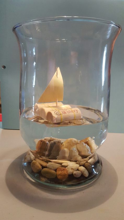 Cork boats! Centerpieces for my wedding! 3 corks 2 Ouchless rubber bands 1 Toothpick Paper Rocks in the bottomof a vase with water Super easy and REALLY cheap! Ship Centerpiece Ideas, Cruise Centerpieces Table Decorations, Nautical Flower Centerpieces, Sailboat Centerpiece Ideas, Boat Centerpiece Ideas, Sailor Centerpieces, Wave Centerpiece, Nautical Centerpiece Ideas, Nautical Table Centerpieces