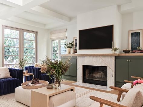 Living room features an oak waterfall coffee table over a light beige ottoman, a deep chairs, a marble and brass fireplace mantel flanked by forest green built in cabinets topped with butcher block and a built in bench with tan striped cushion. Tv Coffee Table, Fireplace Mantel Surround, Julian Chichester, Fireplace Mantel Surrounds, Oak Fireplace, Mantel Surround, Gas Fireplace Insert, Wood Fireplace Mantel, Fireplace Built Ins