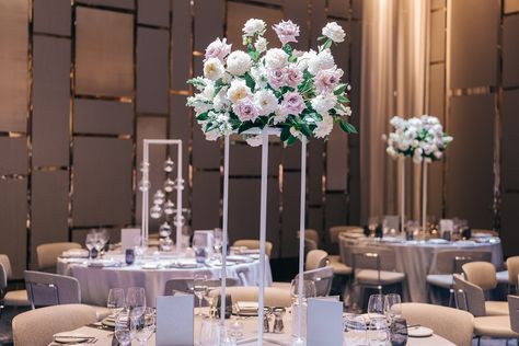 Tall wedding centerpieces are ideal for rooms with high ceilings because they help fill the vertical space, creating balance and a more cohesive visual experience. Without tall decorations, the room might feel empty or cavernous. Florals & Styling: @jewelphonflowers Venue: @crownsydney Photo: @alisterkou #tallcenterpieces #wedding #weddingreceptiondecor #weddinginspiration #weddingplanning #weddingstylist #sydneyflorist #jewelphonflowers #weddingflowers Tall Flowers Wedding Table, Simple Floral Around Tall Cebterleice, White Rose Tall Centerpiece Wedding, Blush Pink Tall Wedding Centerpieces, Pastel Wedding Centerpieces Tall, Tall Wedding Centerpieces, Feeling Empty, Tall Centerpieces, Wedding Stylist