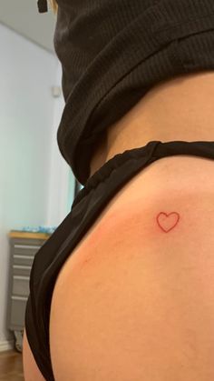 Tiny Red Heart Tattoo Hip, Small Heart Buttcheek Tattoo, Red Tiny Heart Tattoo, Small Heart Tattoos For Women On Hip, Red Heart Tattoo On Shoulder, Red Heart On Buttcheek Tattoo, Simple Red Heart Tattoo, Red Outline Heart Tattoo, Tiny Tattoos Red Ink