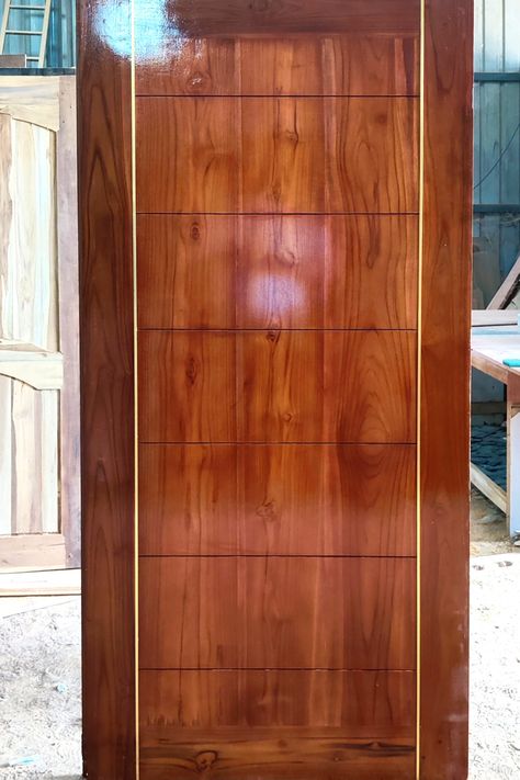 Teakwood plain door with grooves and vertical gold 'T' beading strips. Mahagony colour polish. Door Polish Colour, Teakwood Door Designs, Teakwood Main Door Design, Main Doors, School Door Decorations, Wooden Main Door, Wooden Main Door Design, Home Door Design, School Doors