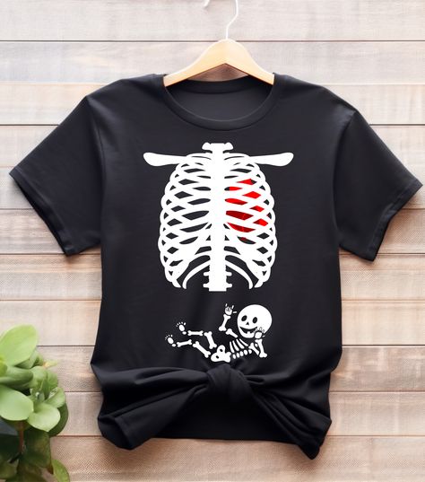 Get into the Halloween spirit while celebrating your pregnancy with our "Spooky and Sweet: Halloween Baby Skeleton Pregnancy Shirt." This adorable and unique maternity shirt combines the joy of impending motherhood with the fun and whimsy of Halloween. #HalloweenPregnancy #fallpregnancy #pregnancyannouncment #pregnancyreveal #MaternityHalloween #Pregot-shirts #Pregnantfallshirts #Halloweentshirts #babyannouncment #Halloweenshirt #Halloweenpregnancy #babyshowershirt #Halloweengift #maternitygift Maternity Halloween, Halloween Pregnancy Shirt, Baby Shower Shirts, Pregnant Halloween, Fall Maternity, Maternity Shirt, Skeleton Shirt, Halloween Baby, Pregnancy Gifts