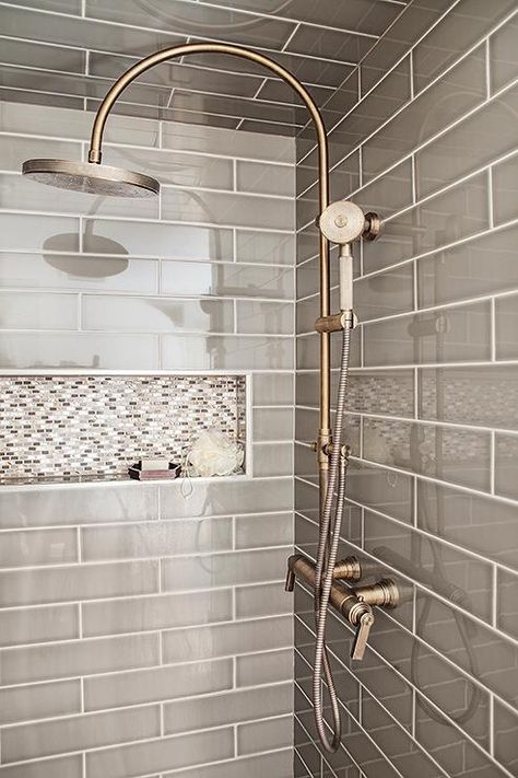 Gray walk in shower boasts ceiling and walls clad in gray tiles fitted with a white and gray mosaic tiled shower niche as well as a vintage style exposed plumbing shower kit. Mosaic Shower Tile, Exposed Plumbing, Tile Shower Niche, Gray Shower Tile, Makeover Kamar Mandi, Subway Tiles Bathroom, Farmhouse Shower, Tile Remodel, Shower Niche