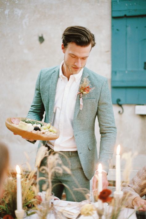 This runaway elopement with southern accents and an artisan feast is too much to handle! Alternative engagement rings, daring color combos and a silky apricot gown are just a few of the eye-popping details you can expect to see in this autumn inspiration on #ruffledblog! Sage Suit Men Wedding, Colored Suit Groom, Groom Suit Italian Wedding, Groom Suit Alternative, Sage Suit Groom, Cool Wedding Suits For Men, Groom Alternative Outfit, Alternative Wedding Suits Men, Summer Groom Suit Ideas