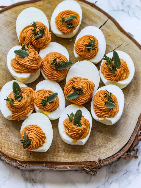 Thanksgiving Deviled Eggs are an easy appetizer party food idea. Gorgeous Fall color, garnished with sage and thyme to celebrate the season. Thanksgiving Appetizers Aesthetic, Fall Crowd Food, Party Food Thanksgiving, Two Person Thanksgiving Dinner, What Order To Cook Thanksgiving Dinner, Thanksgiving Feast Aesthetic, Friendsgiving Buffet Setup, Thanksgiving Plating Ideas, Fall Friendsgiving Decor