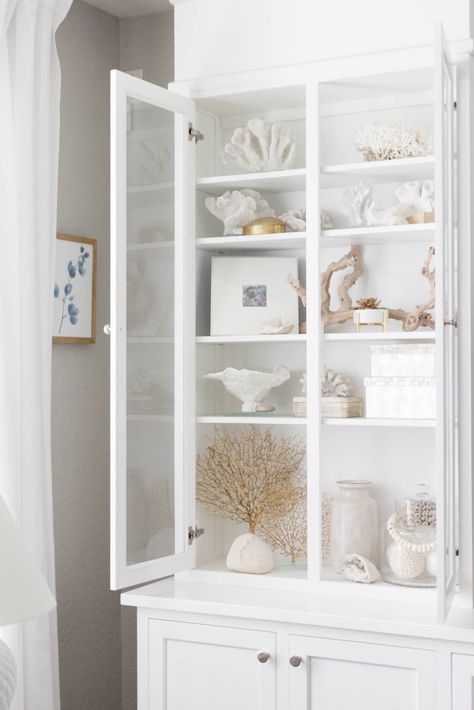 Elegant Coastal Bookcase Styling by Iris Nacole Coastal Bookcase, Glass Display Cabinets, Coastal Chic Decor, Art Deco Style Interior, Bookcase Styling, Coastal Interiors Design, Glass Cabinets Display, Coastal Living Rooms, Coastal Bedrooms