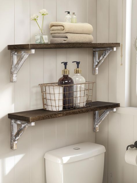 PRICES MAY VARY. This floating shelf set is constructed of durable paulownia wood, featuring a natural wood texture, lightweight, and wear-resistant The wall shelf comes with all necessary mounting accessories, making installation a breeze. Adjust the triangular support position as needed Measuring size: 24*6*6.5 inch, which can effectively expand your storage space. 0.8in thickness plate is not easy to deform and warping Carbonized black plate and whitewashed bracket, a fusion of the rustic and Wood Shelf Bathroom, Small Rustic Bathroom Ideas, Bathroom Wood Shelves, Dark Wood Bathroom, Shelves Over Toilet, Bathroom Shelves Over Toilet, Shelves For Wall, Toilet Shelves, Bathroom Wall Shelves