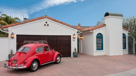 This attractive Mediterranean home features a stucco exterior with red tile roof and walkway with arched columns. Inside, the home features a transitional blend of styles with rustic elements in a bedroom and the dining room, a midcentury modern sitting area, and a contemporary kitchen. White painted brick and exposed ceiling beams can be found throughout the space. Red Tile Roof Exterior Paint Colors, Red Tile Roof, Red Roof House, Mediterranean Patio, Planner 5d, Mediterranean Exterior, Terracotta Roof, Tile Roof, Outdoor Sitting Area