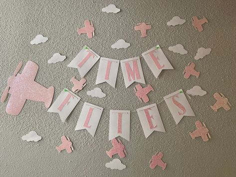 A pink theme airplane birthday party 
“Time flies” in pink letters with a glitter pink airplanes and cloud surrounding the banner. Pink Airplane Birthday Party, Airplane Third Birthday Party, Girls Airplane Birthday Party, Airplane Birthday Theme, Airplane Party Theme, Airplane Birthday Party Decorations, Time Flies Birthday, Pilots Birthday, Planes Birthday Party