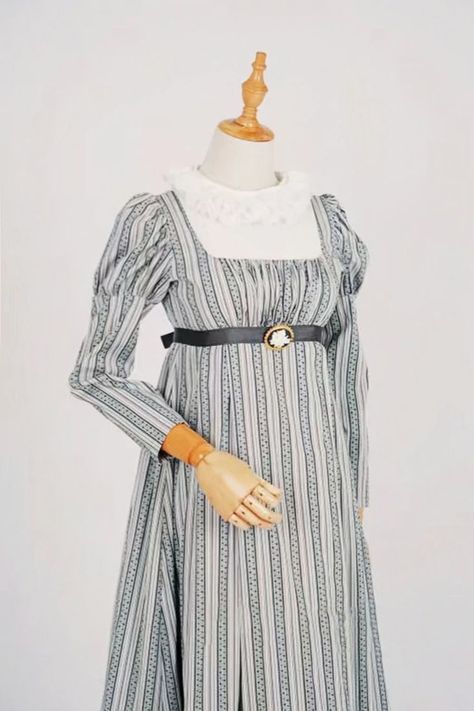 This Regency Era High-necked Striped Grey Dress is perfect for any formal occasion! The high neck and long sleeves are perfect for a more modest look, while the striped pattern adds a touch of fun and whimsy. The fitted bodice and full skirt are flattering on any figure, and the dress is sure to make you feel like a true lady of the Regency Era! Regency Era Wedding, Regency Era Dress, Ball Gown Plus Size, Bridgerton Inspired, Regency Gown, Regency Era Fashion, Plus Size Costume, Regency Dress, Regency Fashion