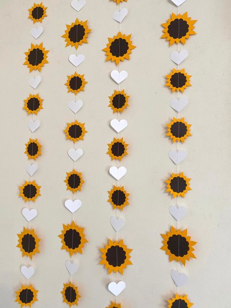 This Anyoccasionbanners sunflower themed garland will be a perfect touch to your event. They work well for a birthday, baby shower or bridal shower. You choose how many single strands you need and the color for the hearts. We've shown 4 strands in the photos. Each strand measures about 3 feet from top to bottom. We used sunflower yellow for the 2 different sized sunflowers and deep chocolate brown card stock for the centers. The sunflowers are 2 inch and 3 inch in size. The 1 1/2 inch hearts are Sunflower Party Ideas Decor, Fall Decor With Sunflowers, Sunflower Party Theme Birthday, Birthday Sunflower Theme, Sunflower Themed Birthday Party, Sunflower Birthday Party Decoration, Sunflower Party Theme, Sunflower Theme Party, Sunflower Party Themes