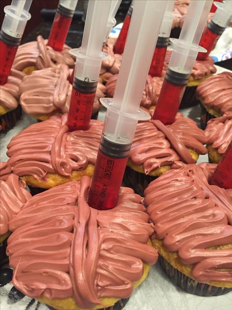 Brain cupcakes with jello syringe shooters. Made by me 10/29/16 for a Halloween themed dinner. Asylum Halloween Party Food, Resident Evil Themed Food, Anatomy Themed Food, Halloween Syringe Ideas, Spooky Hospital Halloween, Oppenheimer Themed Party, Halloween Medical Theme, Hospital Themed Halloween Party, Halloween Hospital Decorations