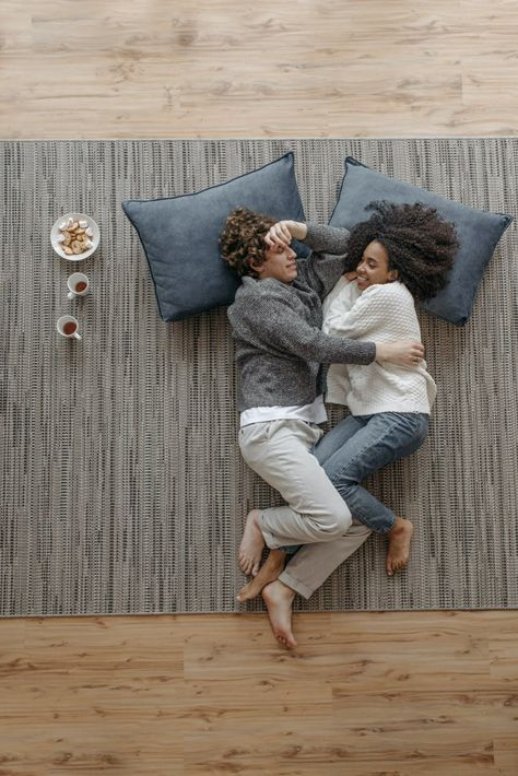 A Couple Lying Close Together on the Floor · Free Stock Photo Person On The Floor, Couple Lying Together, Bed Top View, Sitting Pose Reference, Interracial Couple, High Angle Shot, Couples Play, Grey Bedroom, Sitting Poses