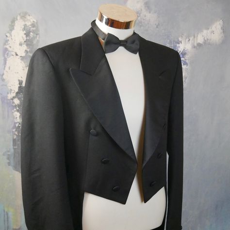 "This European vintage black tailcoat has wide silk peak lapels and padded shoulders, and adheres to the classic full-dress cut style with rounded tails in the back. Six decorative silk buttons feature on the front of the tailcoat, and three buttons decorate each sleeve cuff. The handsome evening tailcoat fits the torso snugly, even though it is cut so that it cannot be closed or buttoned. The way this tailcoat contours to your body will have both a slimming and lengthening effect. This high-qua Steampunk Jacket, Tweed Vest, Shirt And Tie, 1920s Style, Vest And Tie, Full Dress, Custom Suit, Wedding Suits Men, 1920s Fashion