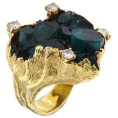 Oversize 18K yellow gold and Chatham emerald crystal ring is Ed Wiener's signature style, circa 1980's. The gold in its organic folded form wraps the crystal as though the gem were rising from the gold, accented by four diamonds, approximately 0.90 cts total weight The ring is not hallmarked but is paired with a matching brooch in this estate offering that is signed. Chatham emeralds Emerald Cocktail Ring, Emerald Cocktail, Diamond And Emerald Ring, Antique Cocktail Ring, Upcycled Gifts, Emerald Crystal, Gemstone Art, Unusual Rings, Art Jewelry Contemporary