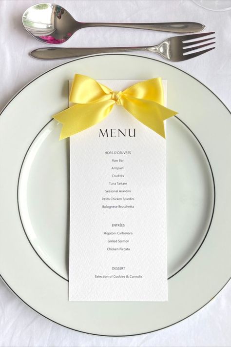 Wedding menu card printed on textured white card featuring a yellow colour satin bow detail at the top. Shown on white plate alongside silver cutlery and a glass tumbler. Pink flowers are in the top left hand corner of the shot Menu With Name, Bridal Shower Place Cards, Yellow Birthday Parties, Rehearsal Dinner Menu, Yellow Wedding Theme, Bridal Shower Menu, Yellow Birthday, Yellow Party, Ribbon Cards