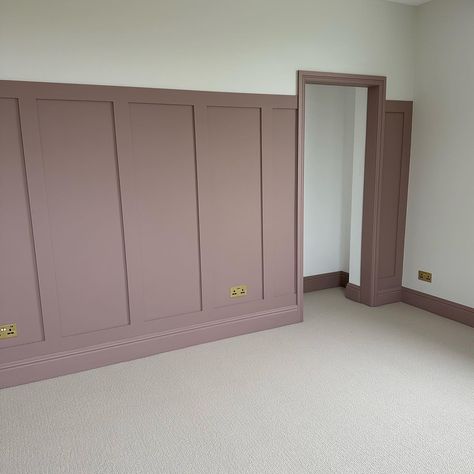 A neutral, textured carpet, paired with panelling and skirting boards painted in a muted, dusky pink tone. The image features traditional style radiators painted in a glossy white shade. Bedroom Inspirations Feature Wall, Panelling Dormer Bedroom, Pink Panel Wall Bedroom, Dusty Pink Dressing Room, Master Bedrooms Decor High Ceiling, Pink Panelling And Wallpaper, Dusky Pink Walls, Bedroom Panneling Ideas Pink, Sulking Room Pink Girls Bedroom