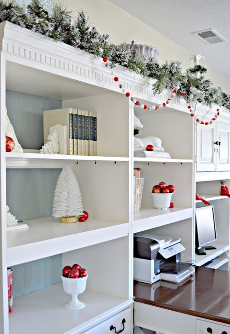 Adding a little greenery with garland and felt garland draped underneath makes this space feel festive. @sliceofsuburbia #HDCHolidayHomes Christmas Decorations For Bookshelves, Garland On Bookshelves, Garland On Shelves, Christmas Decor Ideas For Bookshelves, Bookshelf Garland, Christmas Decor Bookshelves, Decorated Bookshelves, Christmas Bookcase, White Bookshelf Decor