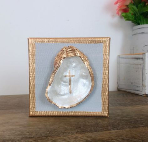 Small Real Oyster Shell on a 4x4 gallery (thick) canvas. Oyster is painted in pearl white, adorned with a simple gold cross, and rimmed in liquid gold leaf. Canvas background is a simple gray, allowing the shell to be the focal point. Perfect little piece to display on a desk or shelf, or on your entryway table. Additional canvas colors available upon request. Just message me and I'll work with you to come up with the perfect piece for your space. Oyster Shell On Canvas, Oyster Shell Art Paintings, Diy Small Canvas Art, Oyster Wall Art, Crafts With Oyster Shells, Oyster Shell Painting, Oyster Shell Crafts Diy How To Make, Painted Oyster Shells Ideas, Painting Oyster Shells Diy